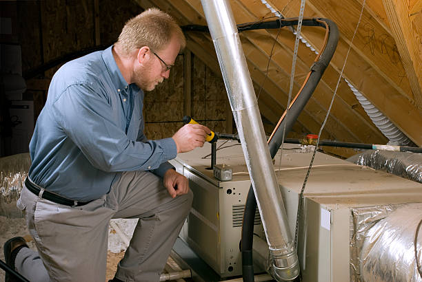 guy looking and diagnosing ac unit in attic