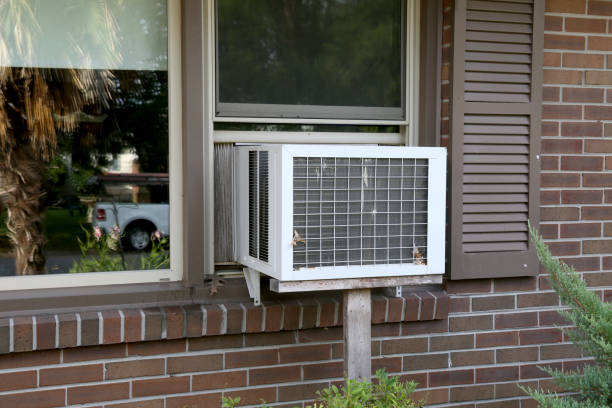 Window AC unit installed in a window on a brick house