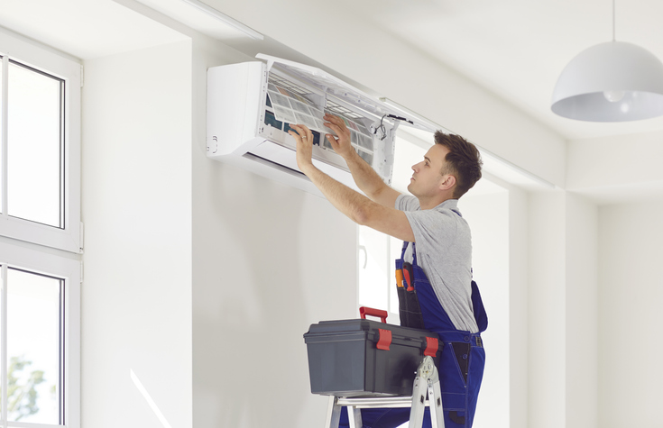 A man inspecting an AC unit