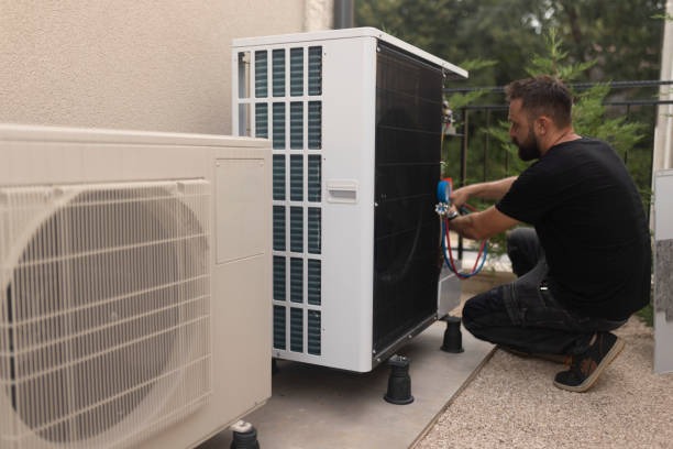 tech working on ac unit outside