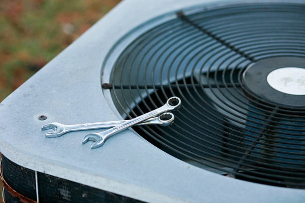 hvac system outside with 2 wrenches on it