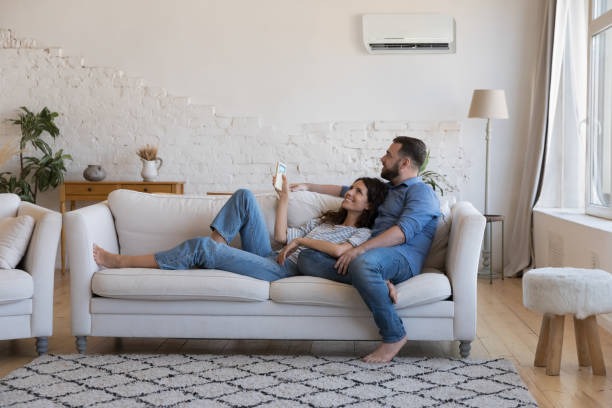 couple sitting on couch together in a modern and clean living room on a light colored couch