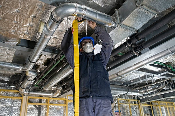 man looking at ducts on ceiling of commercial building under construction