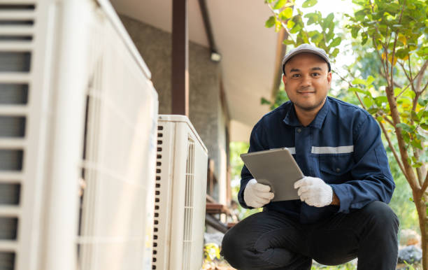Air conditioner service outdoor checking fix repair. Air conditioner cleaning technician He opened the front cover and took out the filters and washed it. He in uniform wearing rubber gloves.