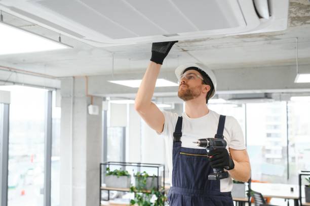 Happy Male Technician Repairing Air Conditioner.