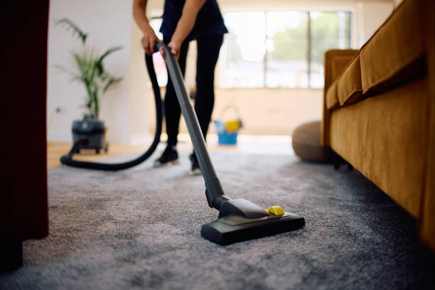 Close up of woman vacuuming while working professional cleaner.